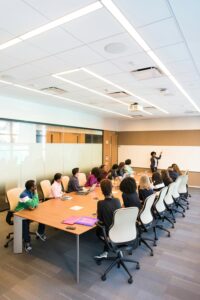 person-presenting-to-a-group-of-people-sat-at-a-board-table