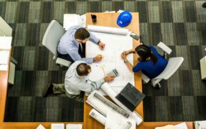 three-people-working-on-a-table-in-a-office