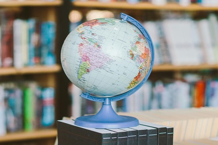 A model globe in front of bookshelves.