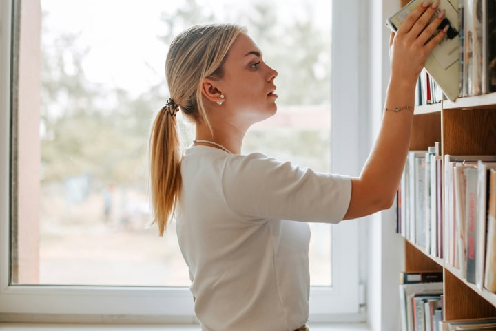 women-picking-book-off-shelve