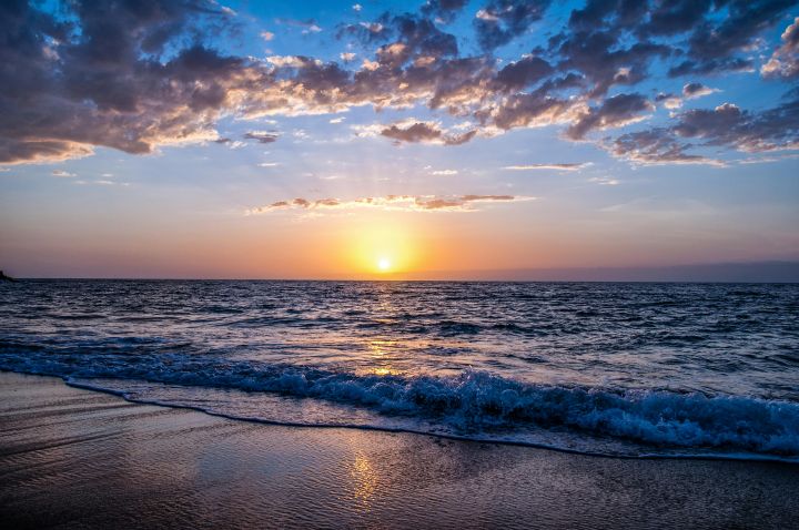 A sunset over a sea; image from Pexels by Bella White.