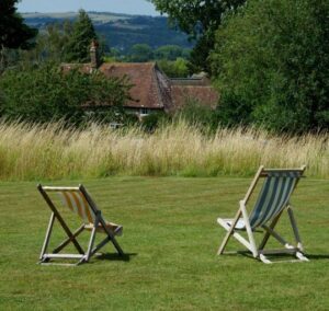 Two deckchairs on a green lawn.
