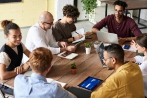 People sat around a table with laptops. Image from Pexels by Fauxels.