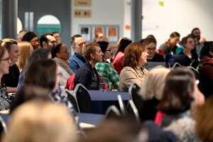 A crowd of people sat in an audience. Photograph from #VitaeCon2025 by Andrew Callaghan.