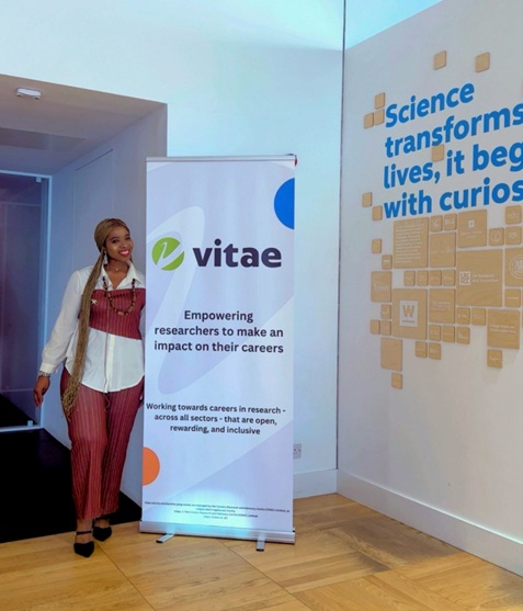 Temitope Odusanya at #VitaeCon2025, standing in front of the Vitae banner.