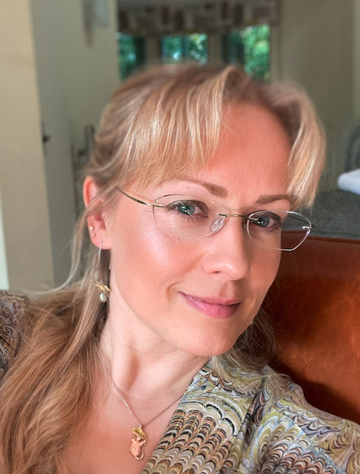 Eleanor Marsden, a white woman with blonde hair and transparent glasses.